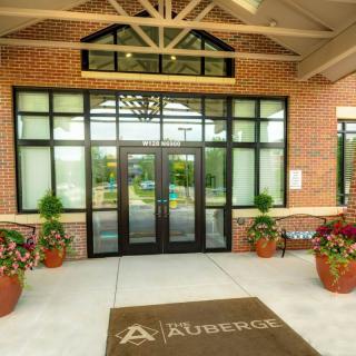 Main entrance of a building with glass doors and potted plants.