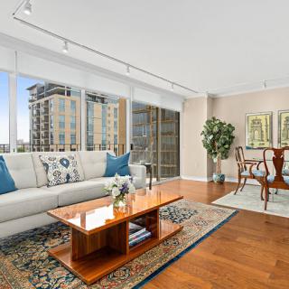 A bright and modern living room featuring elegant furniture and a stunning city view.