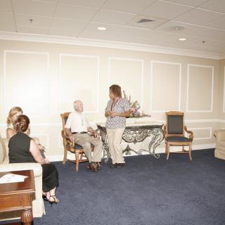 A group of people sitting and conversing in a well-lit room with elegant decor.