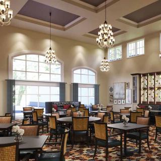 Elegant dining area with chandeliers and large windows.