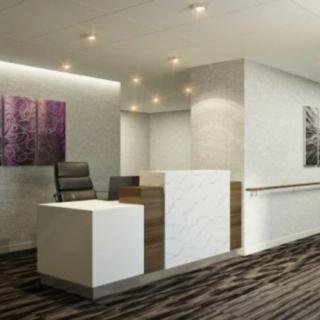 A modern office reception area with a sleek desk and contemporary artwork.