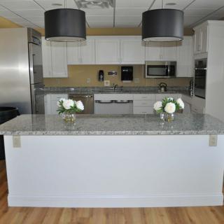 A modern kitchen featuring a central island with pendant lighting and stainless steel appliances.