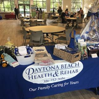 A table showcasing promotional materials for Daytona Beach Health & Rehab at a community event.