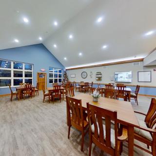 A spacious and well-lit dining area with wooden tables and chairs.