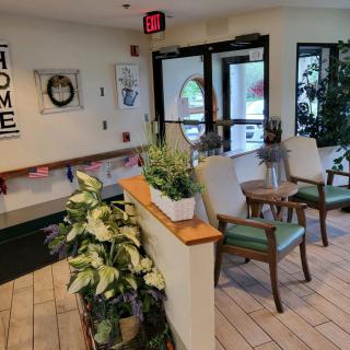 A cozy lobby area with plants, chairs, and welcoming decor near the entrance.