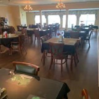 An empty restaurant dining area with neatly arranged tables and chairs.