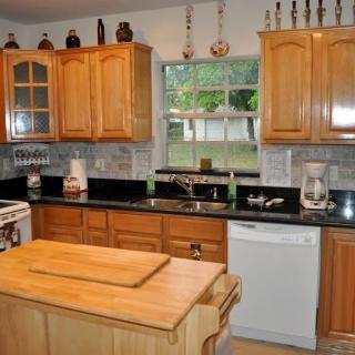 A cozy kitchen featuring wooden cabinets and granite countertops with a central island.