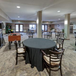 A spacious indoor event area with round tables and a foosball table.
