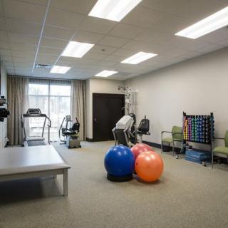 A well-equipped rehabilitation room featuring exercise equipment and therapy balls.