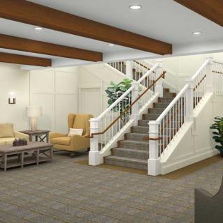 A well-decorated lobby area featuring a staircase and comfortable seating.