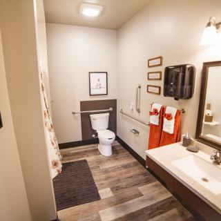 A modern bathroom with contemporary decor, featuring a toilet, sink, and stylish lighting.
