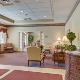 A cozy lobby with comfortable seating, plants, and warm lighting.