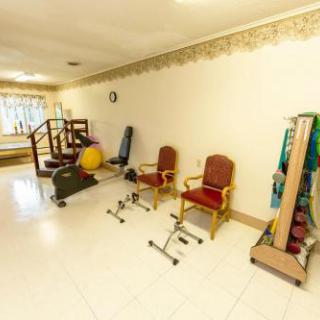 A well-equipped gym space featuring various exercise equipment and seating options for fitness and rehabilitation.