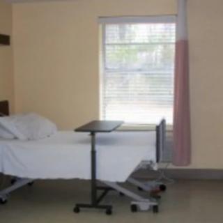 An empty hospital room with a bed and a window.