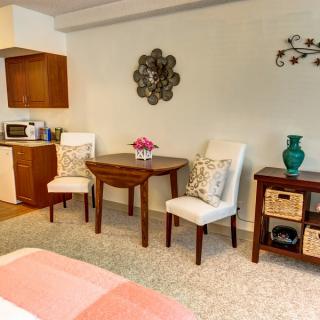 A cozy living space with a small dining area and kitchenette, featuring elegant decor.