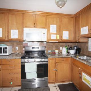 A kitchen with wooden cabinets, a microwave, and an oven.