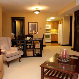 A cozy living space featuring a combined living room, dining area, and kitchen with warm lighting and comfortable furnishings.