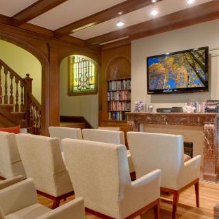 A cozy conference room with comfortable seating and a large TV screen.