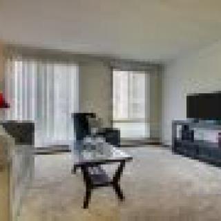 A modern living room with a comfortable sofa, coffee table, and large television setup.