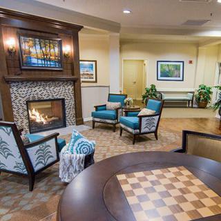 A cozy lobby seating area with a fireplace and chess table.