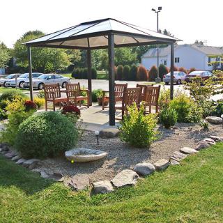A charming gazebo surrounded by landscaped gardens and outdoor seating.