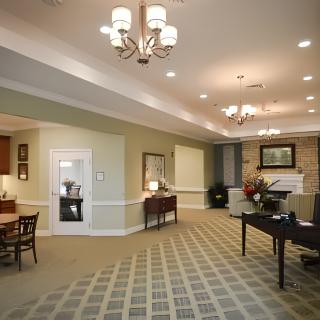 A spacious lobby with elegant chandeliers, comfortable furniture, and a patterned carpet.