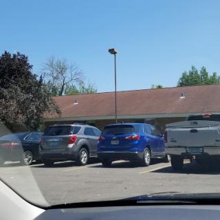 A view of a parking lot filled with various parked cars on a clear day.