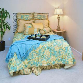 A cozy bedroom with floral bedding and a warm lamp.