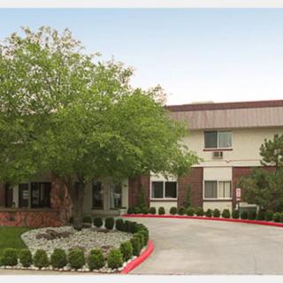 A well-maintained building with surrounding trees and landscaped greenery.