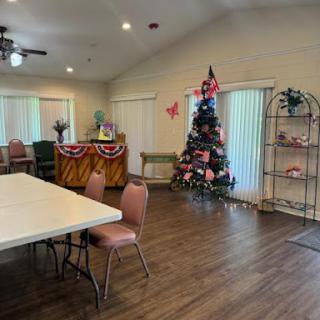 A cozy community center space decorated for the holidays, featuring a Christmas tree and seating arrangements.