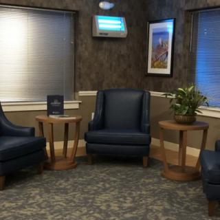 A cozy waiting room with comfortable chairs and side tables.