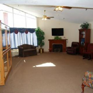 A spacious living room with a fireplace, television, and large windows.