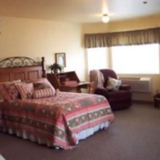 Cozy bedroom with a large bed and seating area near the window.