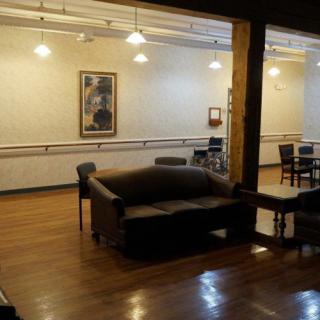 A cozy lounge area featuring a sofa, wooden flooring, and wall artwork.