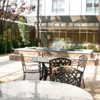 A bright and sunny outdoor patio area with tables and chairs set for relaxation.