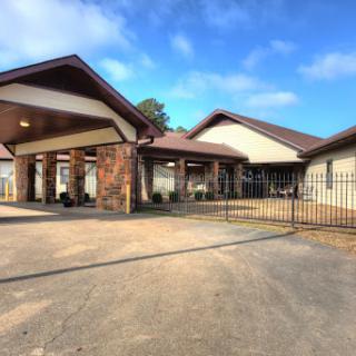 A charming residence featuring a gated entrance and a welcoming facade under clear blue skies.