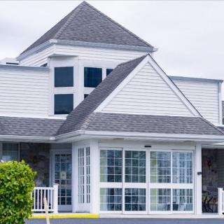 A modern residential house with large windows and a complex roof design.