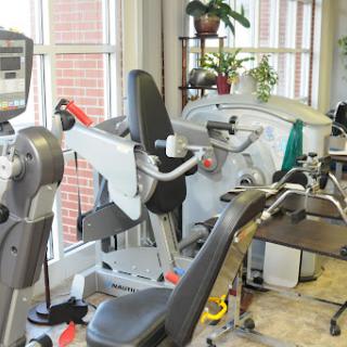 A well-equipped gym area featuring various exercise machines for fitness and rehabilitation.