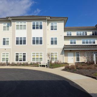 A modern residential building with multiple stories and a spacious parking entrance.