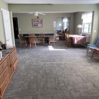 A spacious living area featuring a dining table and comfortable seating, illuminated by natural light.