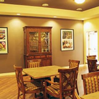 A cozy dining area featuring wooden tables and chairs with framed artwork on the walls.