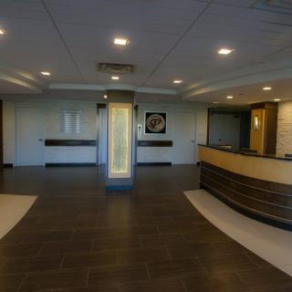 A modern office lobby with a reception desk and overhead lighting.