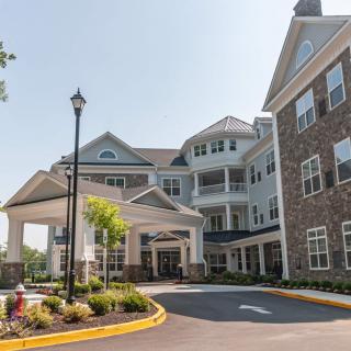 A large residential building with a landscaped entrance and driveway.