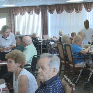 A group of seniors dining together in a restaurant setting.