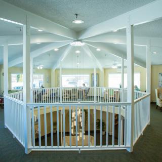 An interior view of a building featuring a dome ceiling and white railing surrounding an open space.