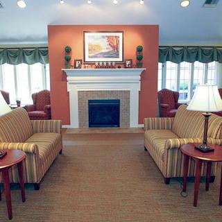 A cozy living room with a fireplace, sofas, and elegant lighting.