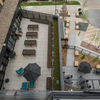 An aerial view of a modern outdoor patio area with tables, chairs, and umbrellas.