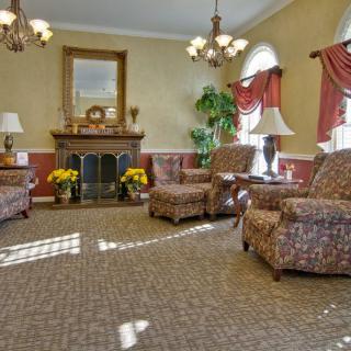 A traditionally styled living room with armchairs and a fireplace.