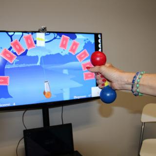A person uses dumbbells in front of a screen displaying an interactive game related to physical fitness.