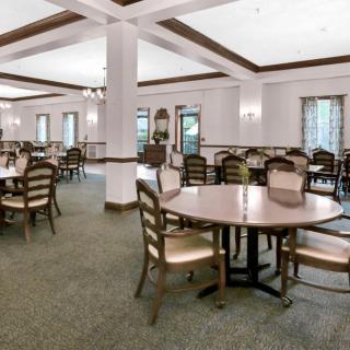A spacious and well-lit dining area with neatly arranged tables and chairs.